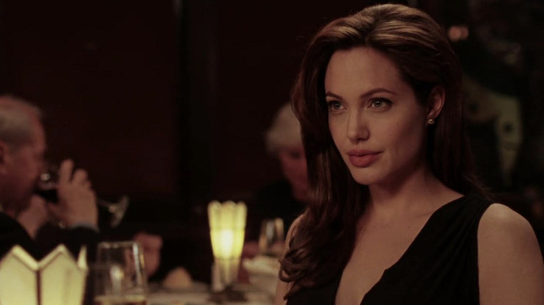 Angelina Jolie looks up at table with small smile
