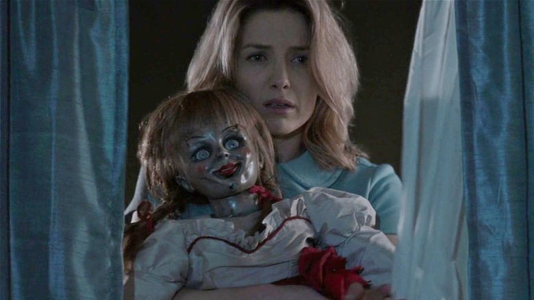 Mia holding Annabelle while looking sad