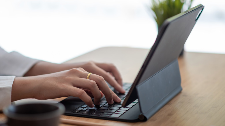 Close up of someone typing on an iPad Magic Keyboard