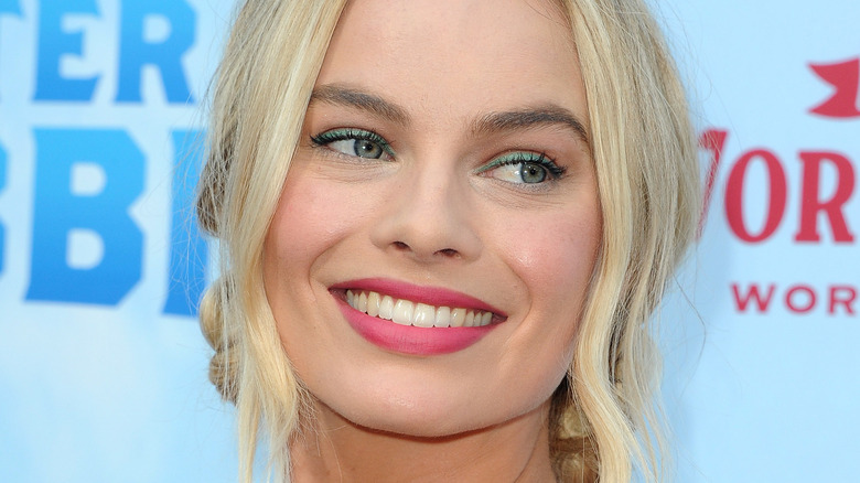 Margot Robbie smiling on red carpet 