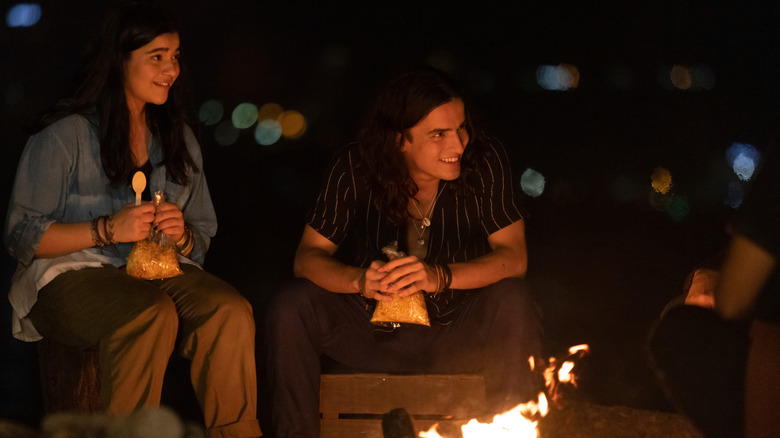 Red Dagger and Kamala smiling around campfire