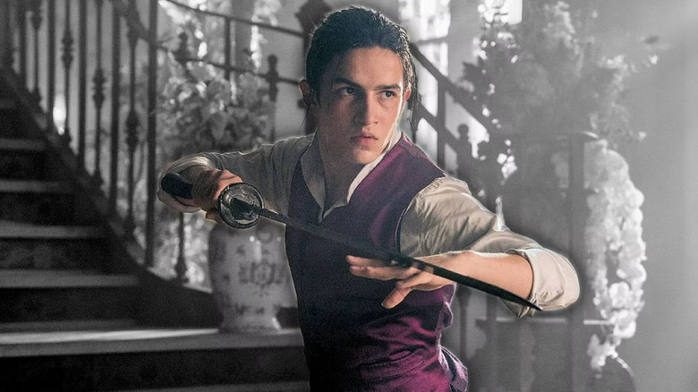 Aramis Knight as M.K. holding sword