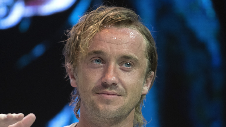 Tom Felton smiling with sweat on forehead