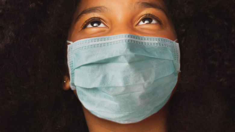 Girl looking up wearing face mask 