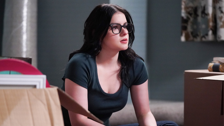 Alex Dunphy sitting on floor surrounded by moving boxes