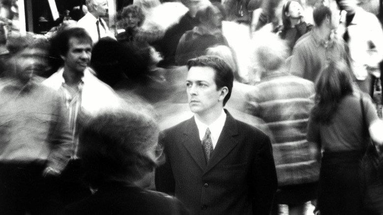 The Young Man standing in the middle of a blurry crowd in "Following" (1999)