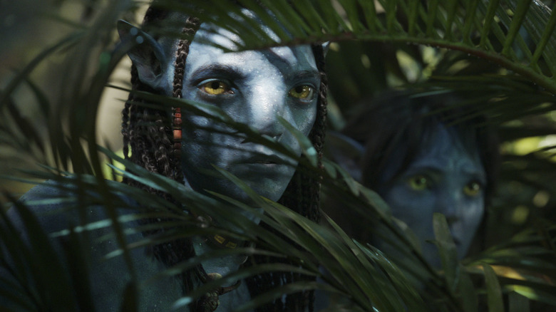 Neteyam and Kiri peaking through vegetation
