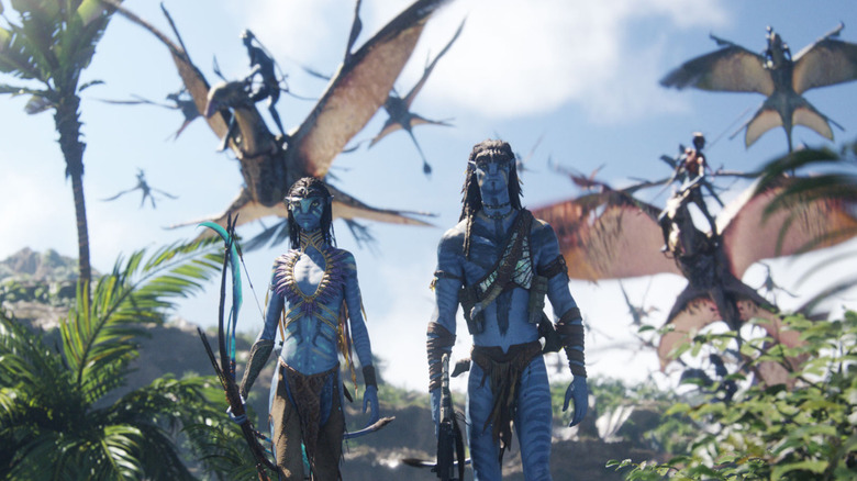 Neytiri and Jake walking in front of other Na'vi (2025)