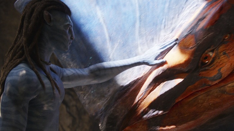 Jake Sully gently petting the head of the Toruk in "Avatar: Fire and Ash" (2025)