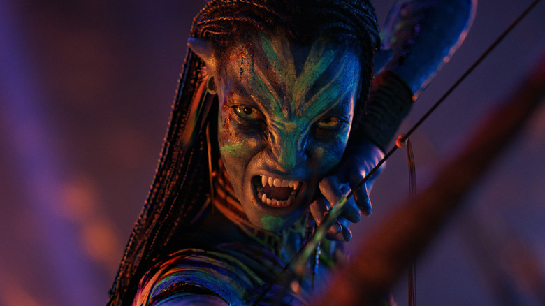 Neytiri snarling and aiming her bow in 