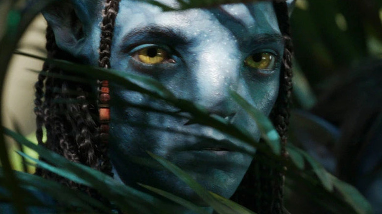 Neteyam peeking through ferns in Avatar: The Way of Water