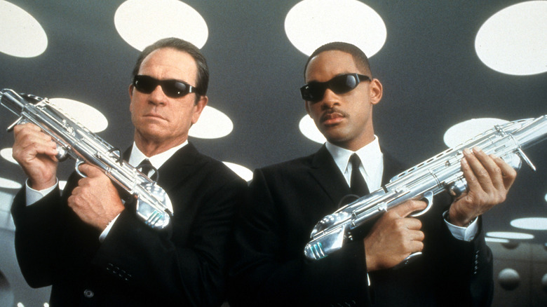 Agent J and K holding guns