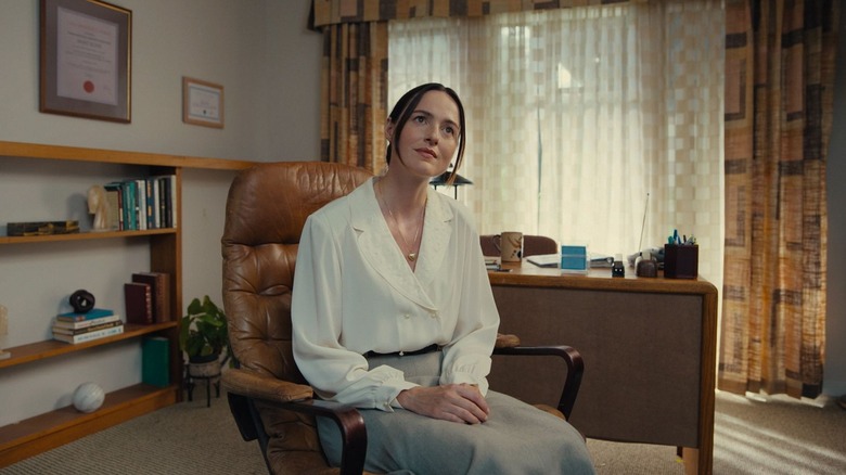 Mary leaning forward in her office in "Backroom" (2026)