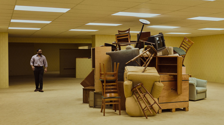 Clark looking at a massive pile of furniture in Backrooms