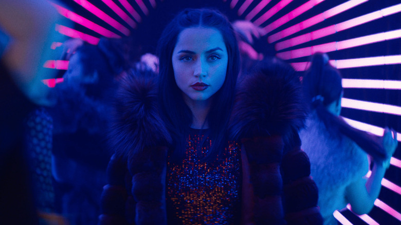 Eve looking ahead surrounded by lights and partiers