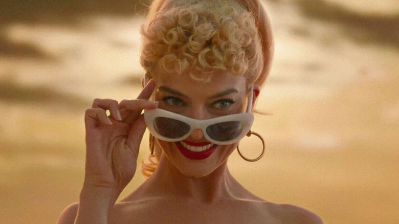 Barbie lowers her sunglasses and smiles