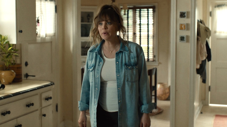 Ava stands in kitchen