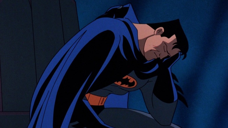 Batman leans down