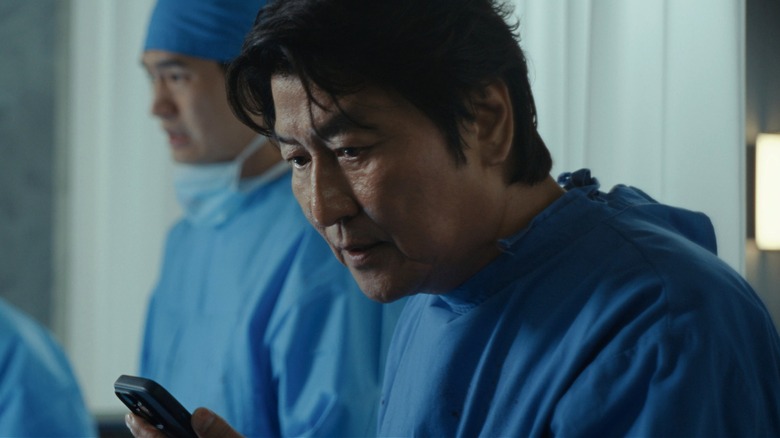 Dr. Kim looking down at his phone in 