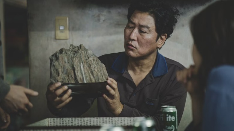 Kim Ki-taek holding a rock ornament in "Parasite"