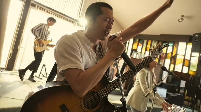 Danny leading worship, singing into a mic with a guitar