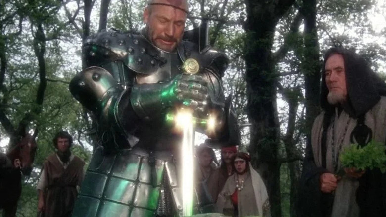 King Leondegrance holding a glowing sword in Excalibur