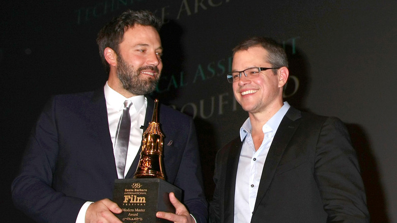 Ben Affleck smiling at Matt Damon at a premier 