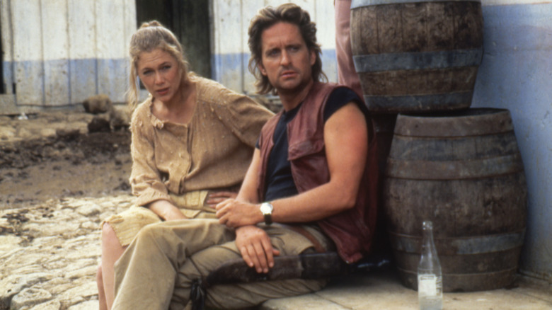 Joan and Jack sitting next to each other in "Romancing the Stone"