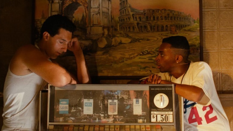 Pino and Mookie standing on opposite sides of a cigarette rack in Do the Right Thing (1989)