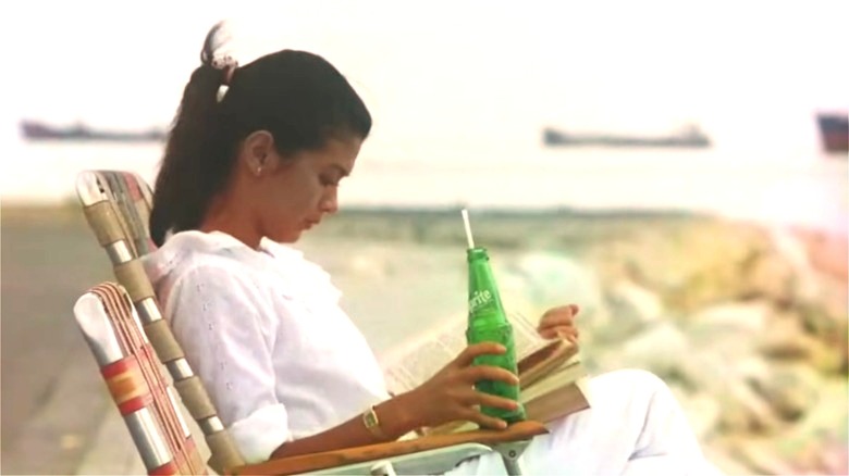 Sylvia reading a book and drinking Sprite by the seaside in Moral