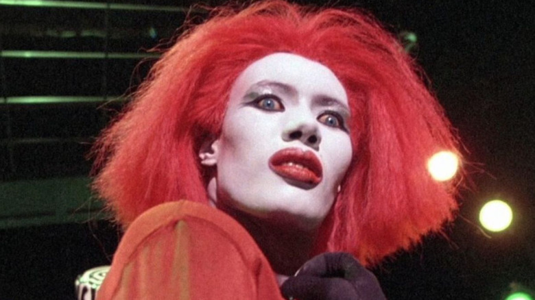 Katrina, in white makeup, gives a wide-eyed glare