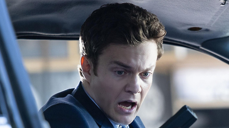 Nathan looking at his hand holding a gun in "Novocaine" (2025)