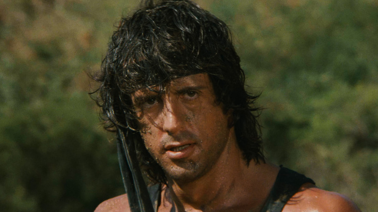 Rambo stands in the forest in 