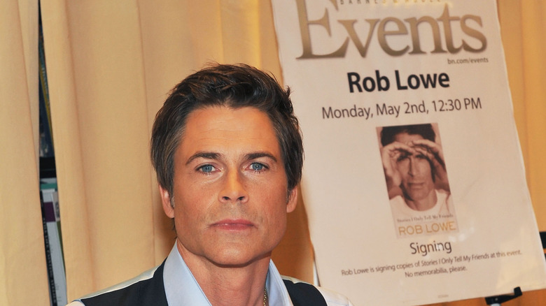 Rob Lowe in front of a poster for his book signing