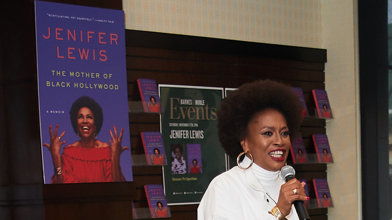 Jenifer Lewis with a microphone in front of a book display