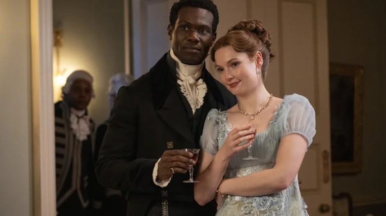 Francesca and John standing together at a party in Bridgerton