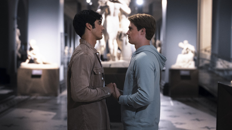 Alex and Henry in a museum holding hands in Red White & Royal Blue