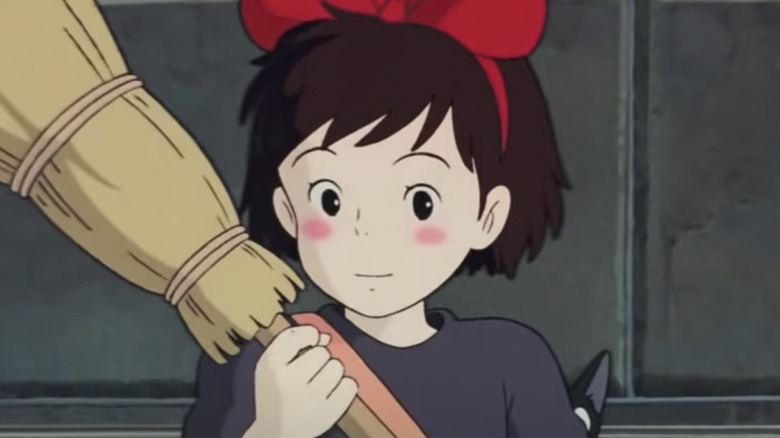 Kiki holds broom