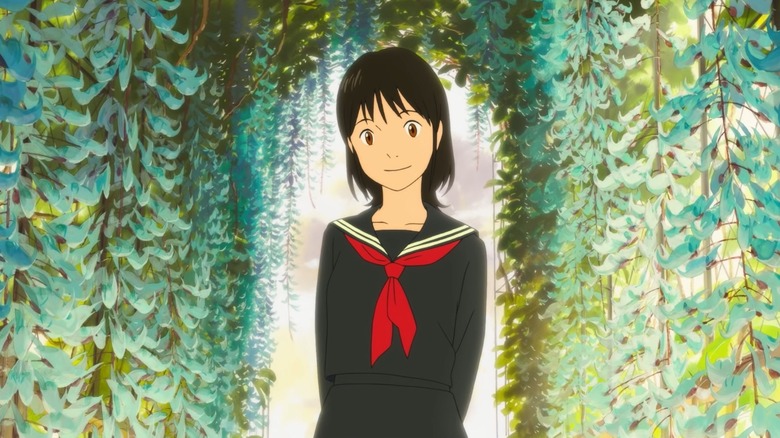 Teenage Mirai in a school uniform smiles in front of flowers