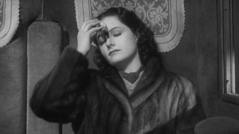 Iris dabbing at her forehead with a handkerchief in The Lady Vanishes