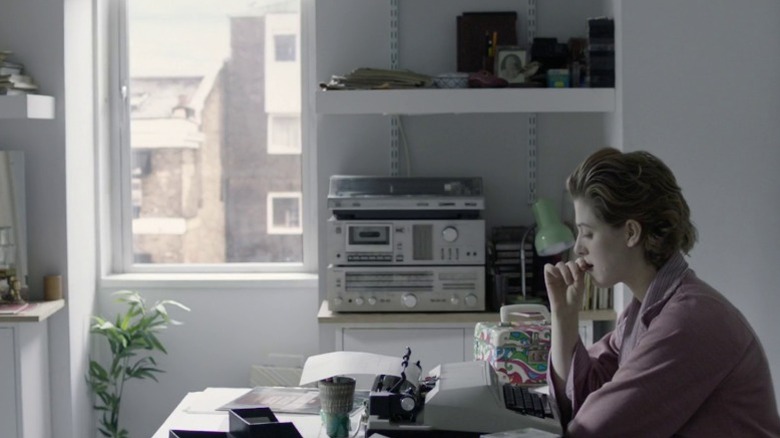 Julie sitting at her typewriter and thinking in The Souvenir