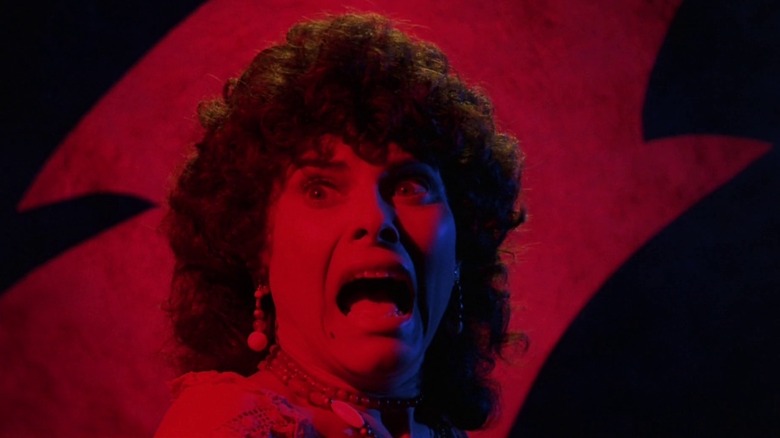 Wilma screams in terror against a red and black background