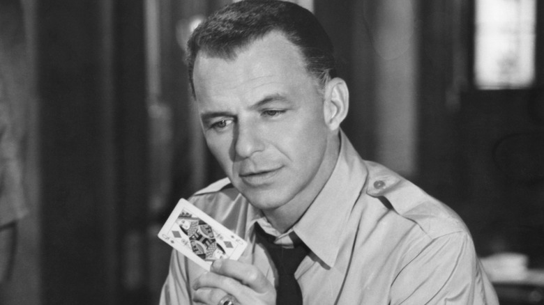 Bennett Marco holds up a Queen of Hearts in 'The Manchurian Candidate' (1962)