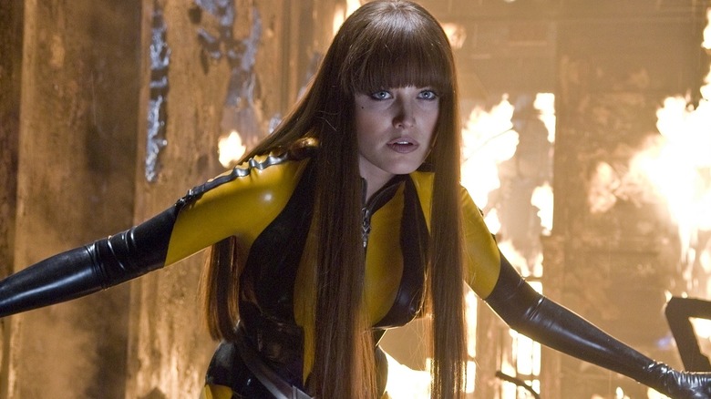 Silk Spectre II posing ready to fight in front of flames