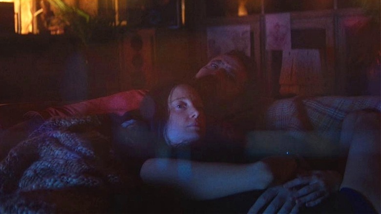 Red and Mandy laying on the couch together in Mandy (2018)