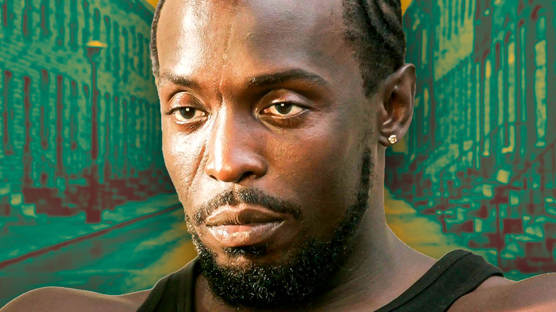 Omar Little looking serious in The Wire with a green background of Baltimore