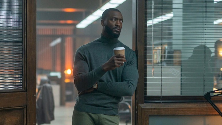 Alex Cross holding a cup of coffee in Cross