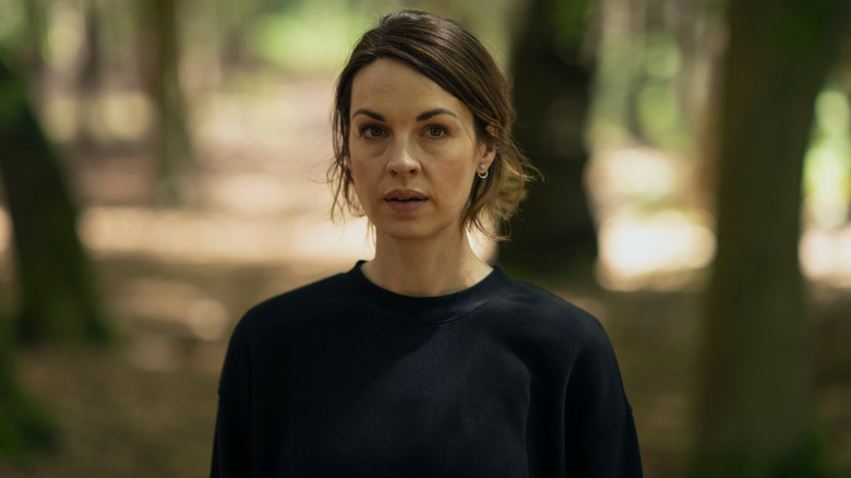 Lucy Chambers standing in the woods in The Devil's Hour