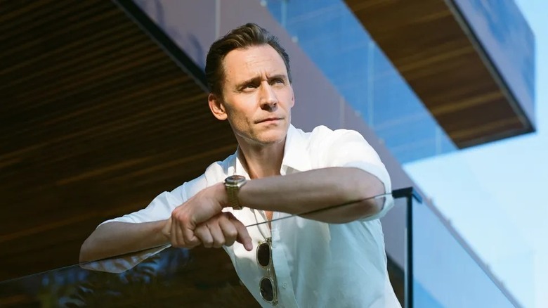 Jonathan Pine leaning over a glass balcony in The Night Manager