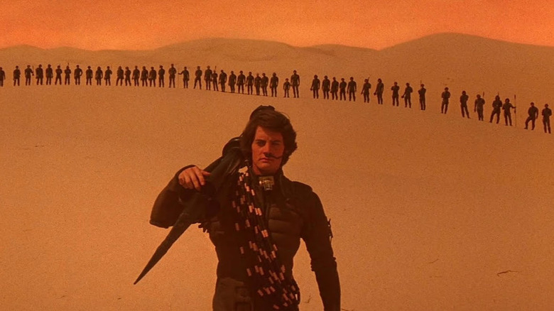 Paul Atreides stands before a line of Fremen in the Arrakis sands